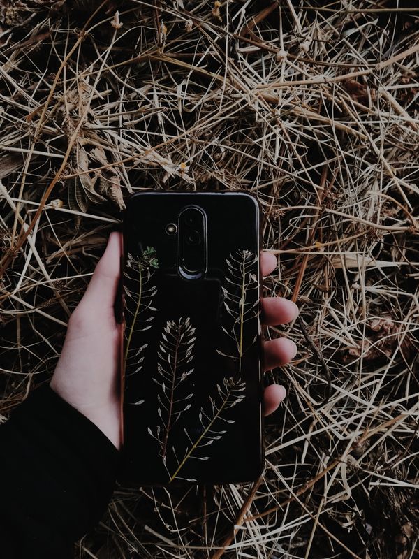 Smartphone i et mønstret mørkt cover