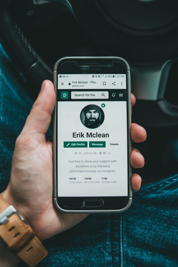 Hånd der holder en brugt smartphone med en app åben